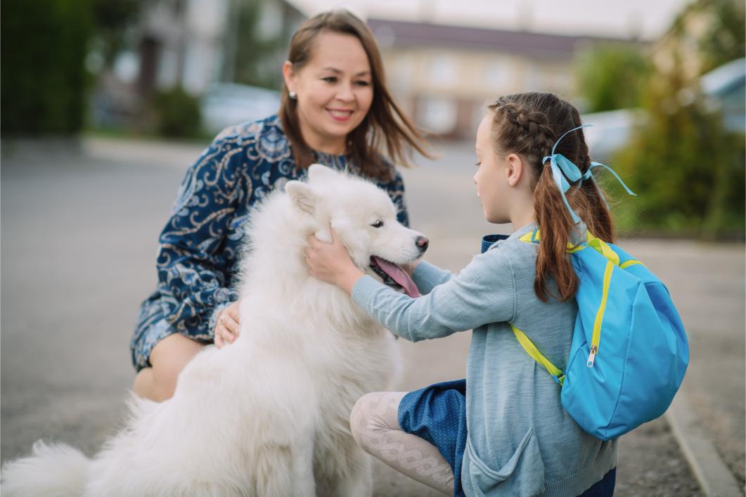 girl hugging dog before going to school